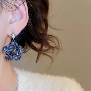 Blue rose drop earrings with micro-inlaid cubic zirconia on a female model