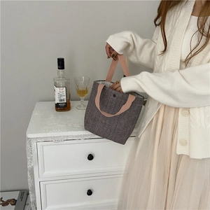 Detail of wool lunch bag with black white chevron pattern and pink woven handles