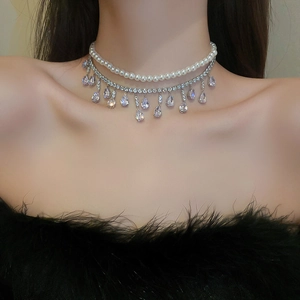 Dettaglio collana a due strati con perle, strass e ciondoli a forma di goccia d'acqua