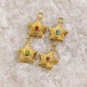 Golden star-shaped stainless steel charms with colorful gemstones on a soft white background