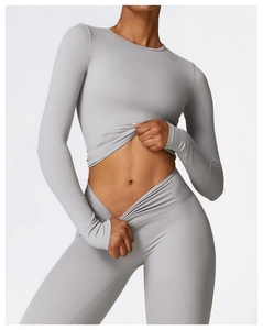 Detail of high-stretch light grey long sleeve yoga top and high-waist fitness leggings