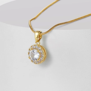 Macro shot of gold pendant with large round zircon surrounded by micro diamonds