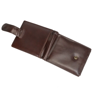 Close-up of deep brown genuine leather wallet with bronze snap button and textured finish