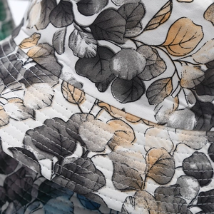 Close-up of canvas bucket hat featuring precise stitching and leaf pattern texture