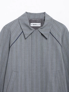 Close-up of gray pinstripe varsity jacket collar with detailed stitching and brand neck label