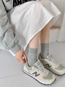 Detail showing elastic ribbed cuff and vertical pinstripe texture on gray crew socks