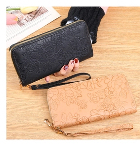 Detail of long zip wallets with 3D floral embossing and detachable wrist straps