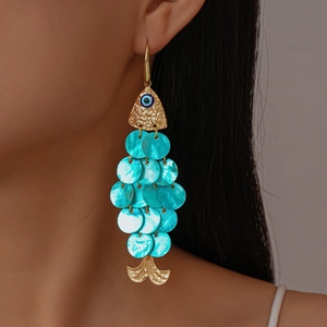 Detailed view of fish-shaped earring with evil eye bead and turquoise shell scales