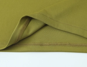 Macro del tessuto a maglia verde oliva con cucitura piatta sull'orlo del vestito lungo