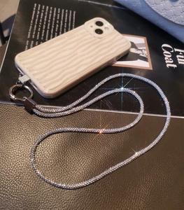 Close-up of luxury rhinestone phone strap with wave texture cream mobile case