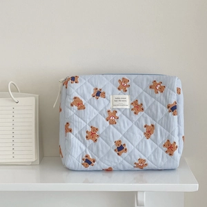 Detailed macro view of blue striped bear pattern quilted fabric and zipper of the cosmetic bag