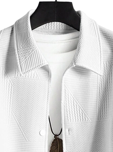 Close-up of white jacket with geometric texture, classic collar, and feather pendant detail