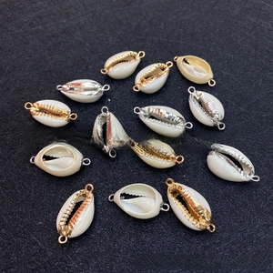 Dettaglio macro di connettori in conchiglia naturale con bordi placcati oro e argento