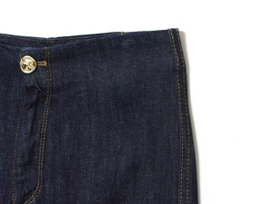 Détail de la taille d'un jean bleu foncé avec bouton doré et coutures contrastées