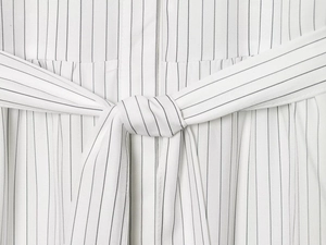 Detail shot of the adjustable waist tie and stripe pattern on this long sleeve dress