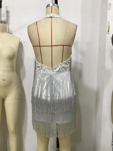 Dettaglio dell'abito con paillettes bianche, frange argentate e spalline incrociate sul retro