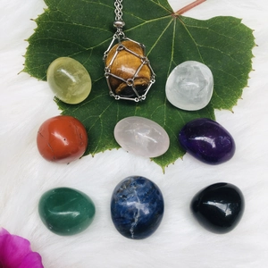 Tiger eye stone necklace with crystal set displayed on green leaves and white fur