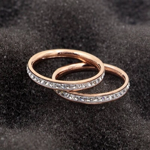 Close-up detail of elegant rose gold titanium steel rings with a single row of crystals