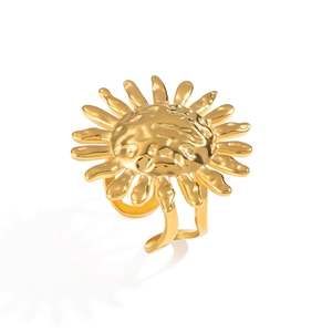 Detailed view of a vintage hammered gold sunburst flower ring on white backdrop