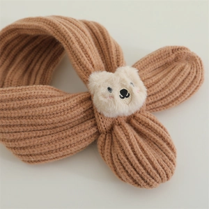 Detailed texture of ribbed knit scarf with a 3D plush teddy bear mascot for kids