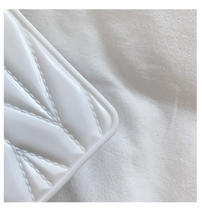 Close-up of white glossy heart silicone bag showing luxury quilted diamond patterns