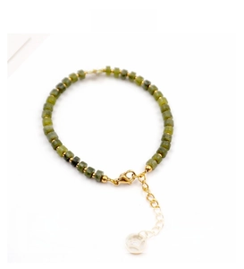 Détail du bracelet en jade vert avec perle blanche et fermoir mousqueton doré chic