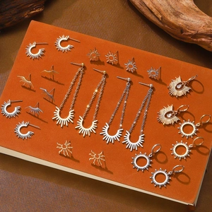 Vintage sunburst earring set in gold and silver finish on a notebook background