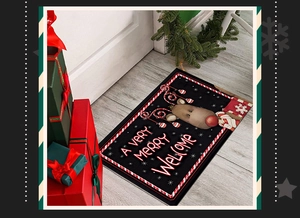 Close-up of black Christmas welcome mat with reindeer and candy cane border on wood floor