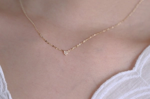 Detailed view of pavé heart pendant with micro-set zircons on a gold-plated link chain