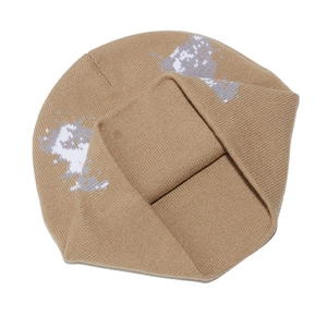 Gros plan du bonnet en maille camel avec motifs pixelisés et texture côtelée détaillée