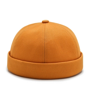 Unisex yellow cotton brimless docker cap with minimalist twill texture and top button detail