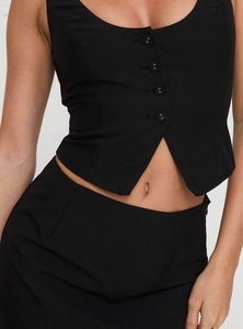 Detailed close-up of slim fit black vest featuring button closure and twill fabric texture