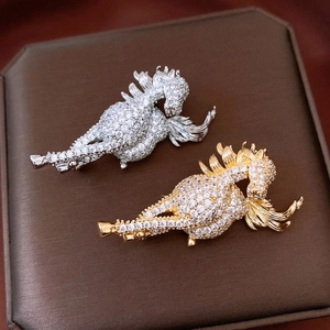 Macro shot of 14K gold plated horse brooch with sparkling zircons on jewelry pad