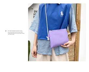 Detail view of purple canvas crossbody bag with white rope strap on a female model