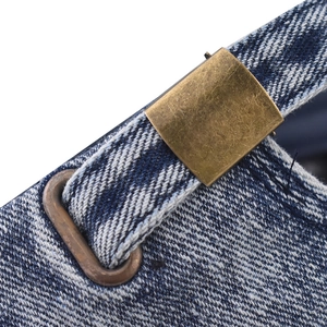 Detail of adjustable vintage brass buckle on washed denim baseball cap with sturdy stitching