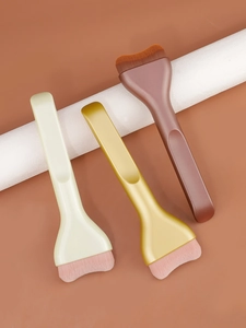 Macro detail of wide flat foundation brushes with curved bristles and ergonomic handles