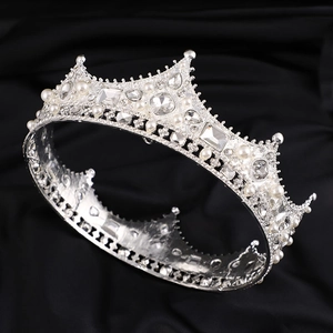 Vintage European Baroque silver crown with pearls and rhinestones on a dark fabric background