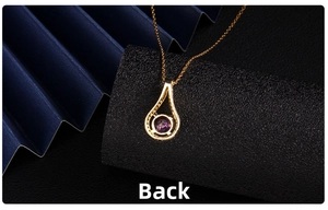 Close-up showing the detailed back structure of a golden purple zircon heart necklace