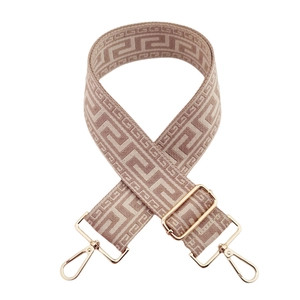 Detail of adjustable geometric Greek key pattern shoulder strap with gold metal hooks