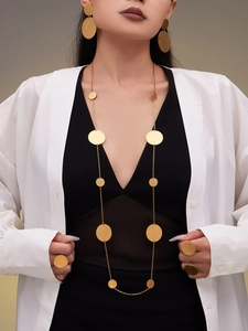 Parure de bijoux dorés à disques ronds avec collier long, boucles d'oreilles et bagues sur mannequin