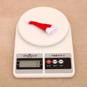 Mini red and white non-woven Christmas hat accessory weighing approximately 1 gram