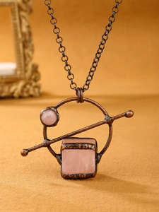 Macro shot of vintage copper necklace with square pink quartz stones and antique texture