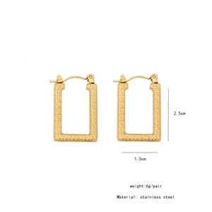 Detail view of gold rectangle earrings with geometric pattern and dimensions 2.5cm x 1.5cm