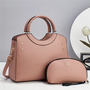 Detail of dusty rose litchi leather handbag set with gold hardware and tulip decoration
