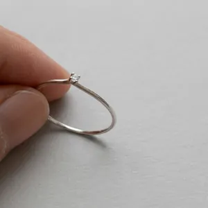 Macro shot of minimalist 925 silver ring with a small sparkling zircon stone detail