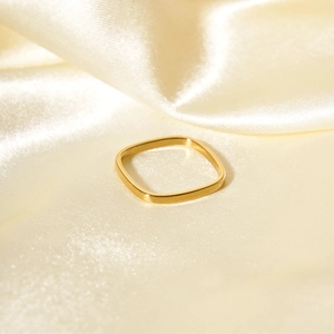 Minimalist square golden ring for women displayed on elegant yellow silk fabric