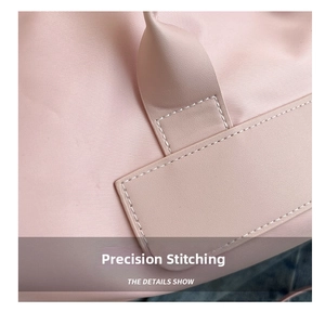 Detail of reinforced stitching on the pink gym bag handle with fine texture fabric