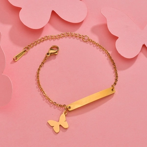 Polished gold rectangular plate bracelet with butterfly charm on pink background