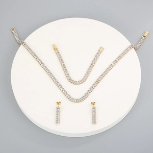 Detailed macro view of gold-plated tennis jewelry set with rectangular zircon stones