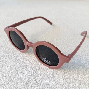 Detail of round matte sunglasses featuring UV400 protection and CE certification labels